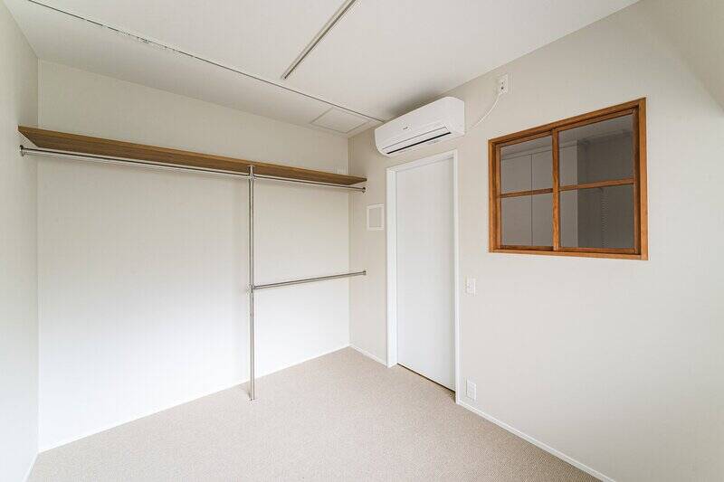 洋室はオープン収納付き（天井にカーテンレールを設置済み）。廊下側に室内窓を設けることで、開放感を増しています。