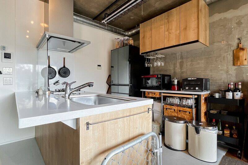 対面式のキッチン。壁面には吊り戸棚や調理家電を置けるラックが付いています。