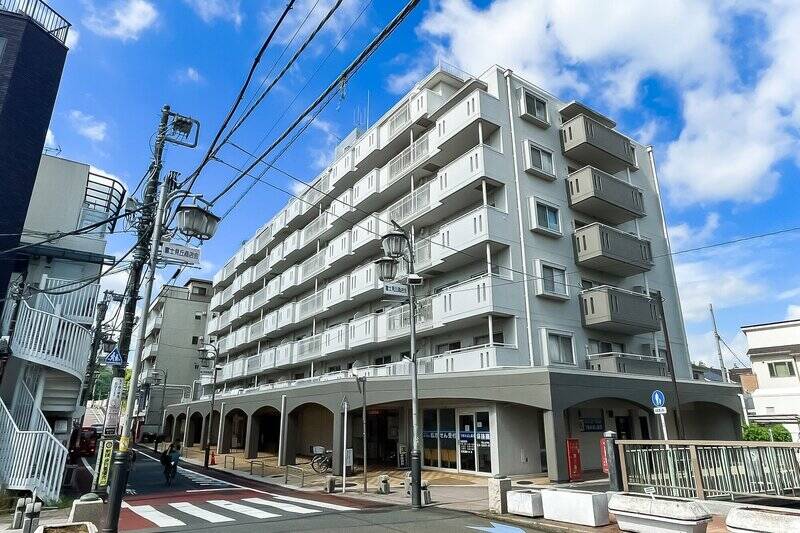 神田川に沿うように建つ大規模マンション。１階部分には小洒落た飲食店などが並んでいます。