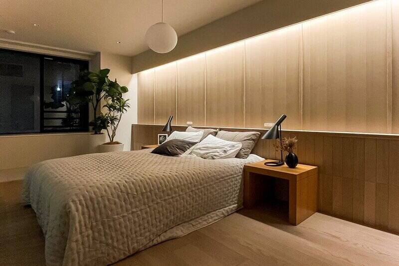 壁一面に設けられた間接照明がベッドサイドを演出。