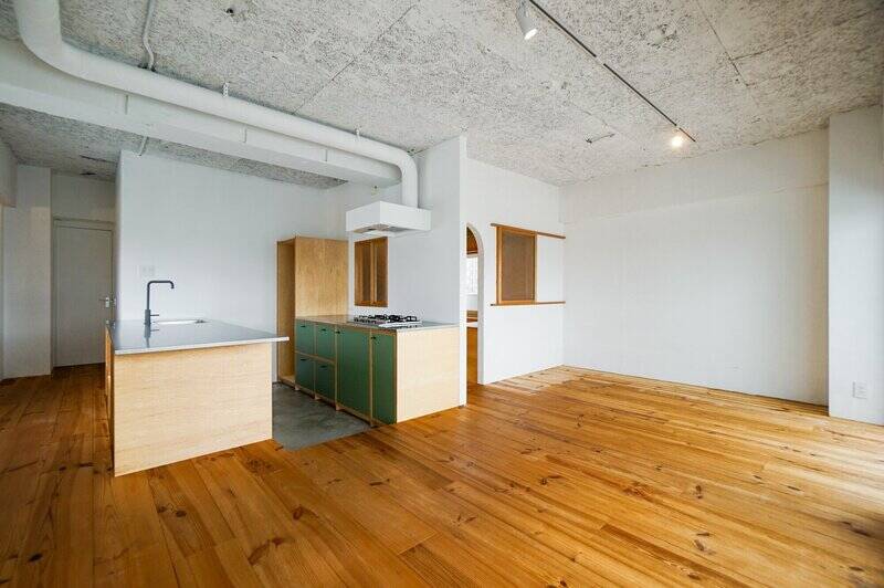 足元はパイン材のフローリングで、天井は木毛セメント板。壁はすべて白塗装で仕上げられています。キッチンとリビングダイニングで高さが変えられているのは、キッチンに立つ人とテーブルの人とで視線の高さを合わせるための工夫だそう。素敵♡