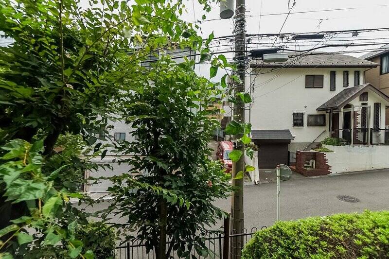 バルコニーに出ると、植栽の向こうに前面道路が見えます。坂道に建っているマンションなので、こちらの住戸はエントランスと同じフロアなのですが、実質地上２階の高さです。通行者と視線の高さが違うため、気楽に過ごせそうですね。