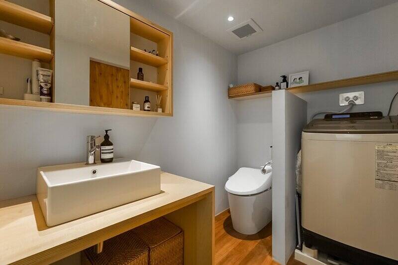 洗面・トイレは一体型。洗濯機置き場との間にある腰壁が、空間をやんわりと間仕切りしています。