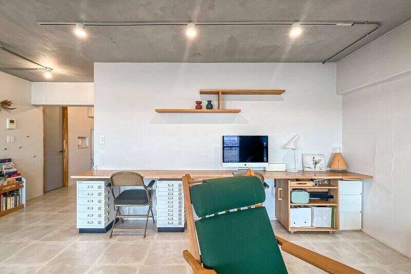 脚のない一枚板の長いカウンター。おふたり並んで作業しても適度な距離を保てるのだそう。壁面の造作棚はキッチンとお揃い。