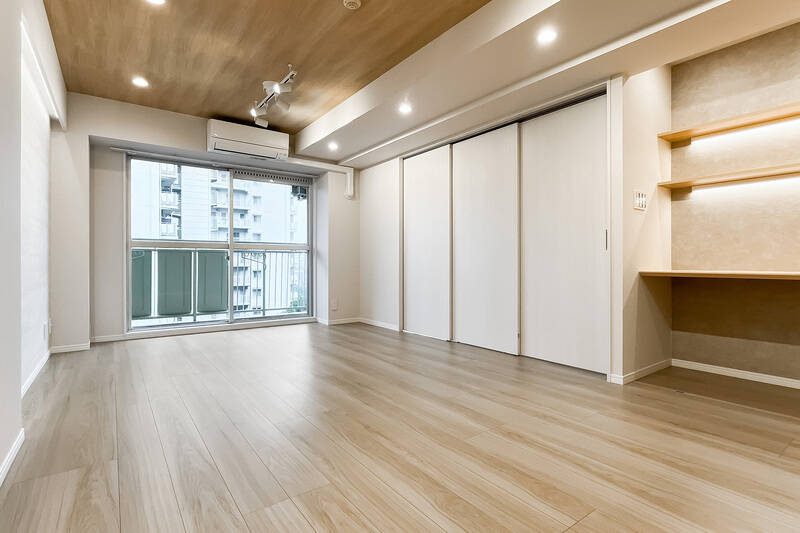 LDKは南向き。天井は床と雰囲気を揃えた木目調で、埋め込み型の照明とダクトレールライトがやさしく照らす空間です。