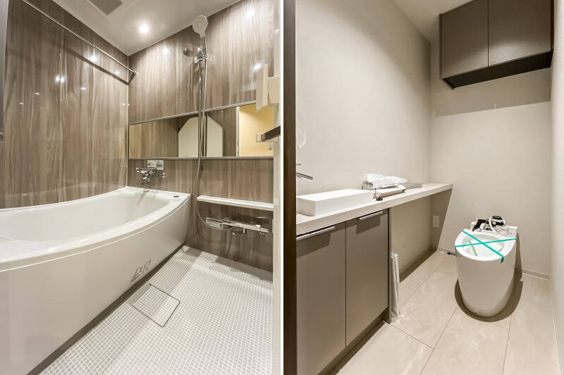 <b>左・</b>LDKの内装と合う木目調のユニットバス。/<b>右・</b>取材時はトイレが設置中でした。タンクレスタイプで、手洗い器も付いています。