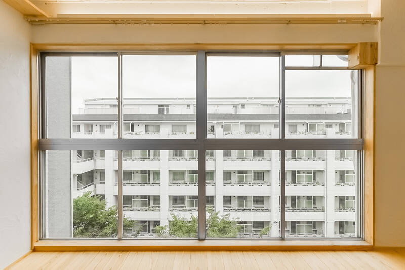 窓の向こうには、お向かいのマンションの共用廊下。人の行き来がふと目に入る距離感で、タイミングによっては視線が気になるかも。