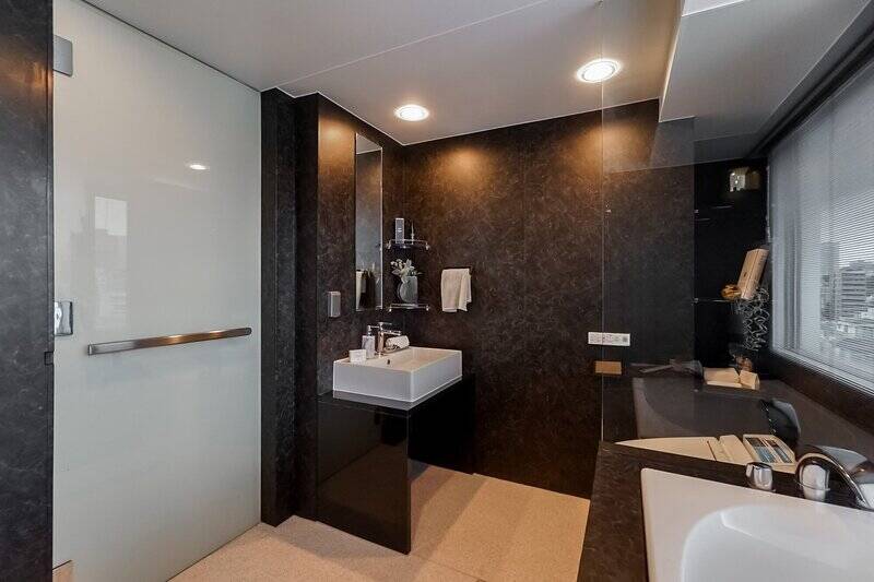 ガラス壁で緩やかに区切られた奥に、洗面台とトイレが。ホテルのような3in1スタイルにすることで、それぞれの場所で余裕ある広さが感じられます。一気にまとめてお掃除できるのもメリットですね。