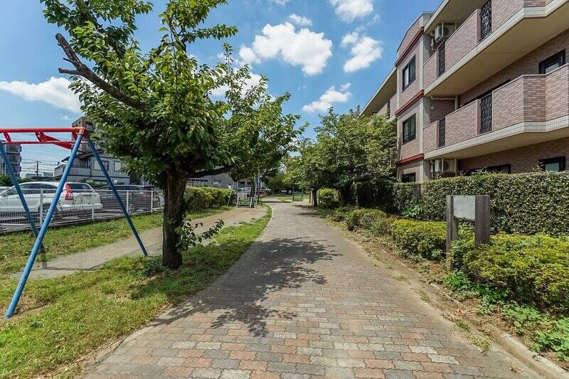 右手に見えている建物の2階の住戸が、ご紹介の物件です。<b>「さくらの散歩道」</b>をジャストミートに見下ろす格好なのが伝わりますでしょうか? 遊歩道内には遊具やベンチが備わっており、お子さまの気軽な遊び場としてちょうどよさそう!