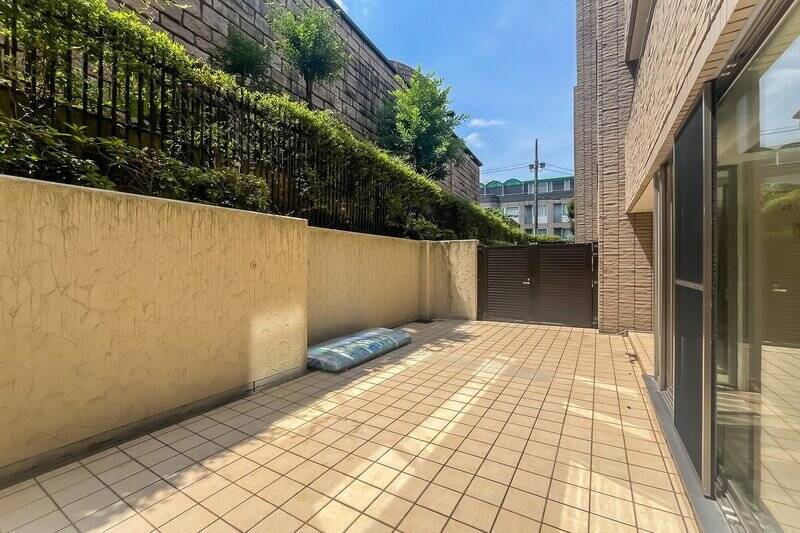 専用庭は手入れがしやすいタイル敷き。まわりの塀や植栽、門扉の背が高いので、視線は気になりません。