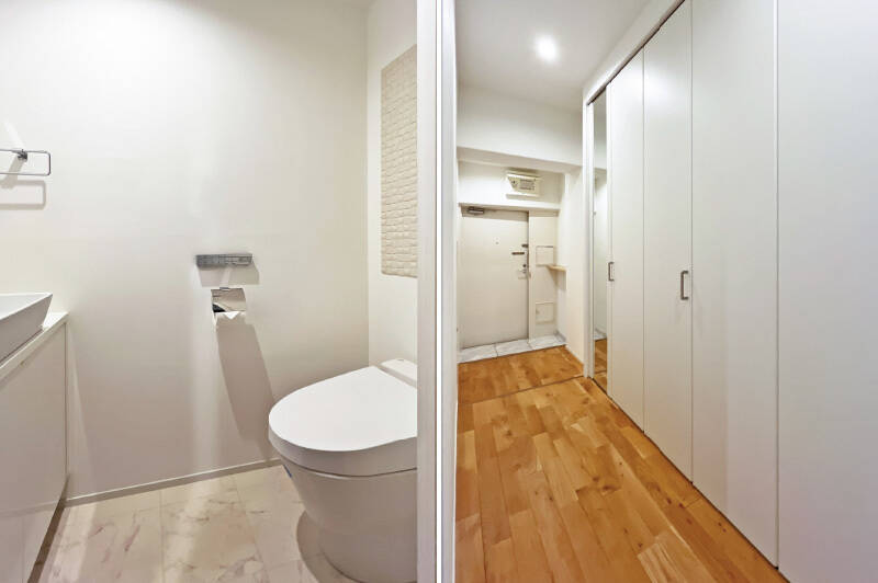 <b>左・</b>廊下沿いに独立したトイレには手洗いボウルも。/<b>右・</b>廊下沿いにもずらりと収納が。これは頼もしい!例えば、半分は下足入れとして、半分は日用品の買い置き収納としての利用はいかがでしょうか。