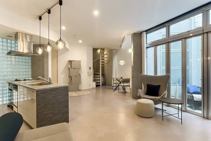 白とグレーを基調としながら、コンクリート打ちっぱなしの柱やガラスブロックでリズムが生まれている空間。よくある長方形ではないことで、居場所をたくさん用意できそうなリビングダイニングです。