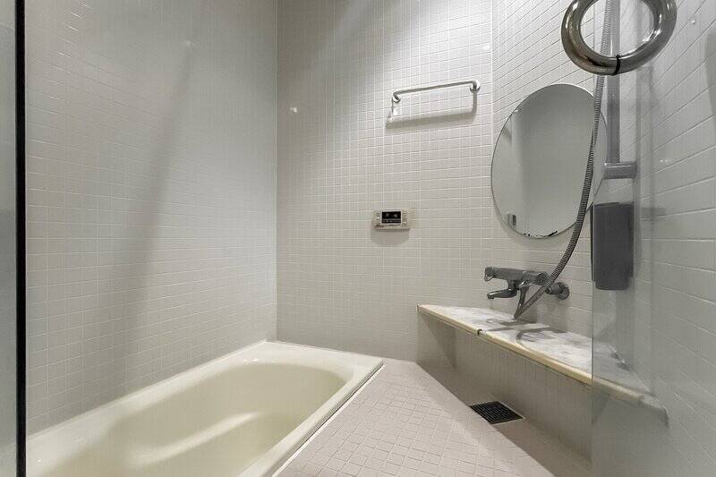 バスタブはユニークな埋め込み型。丸いミラーなどの可愛さにも目を奪われますが、追焚き機能付きで設備面もGood。