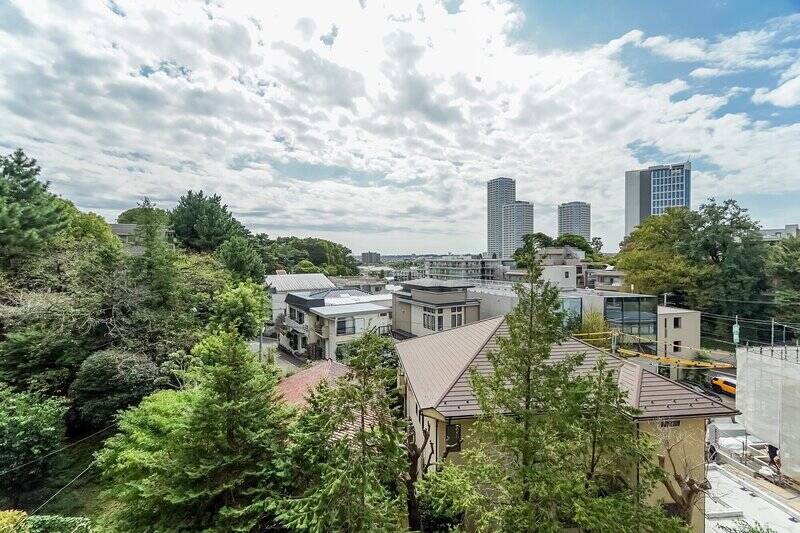 高台に建つマンションの6階に所在する住戸。近隣の豊かな緑と、大きな空を楽しめる気持ちのいい眺め。右手奥には、お隣の二子玉川の高層ビル群が見えています。