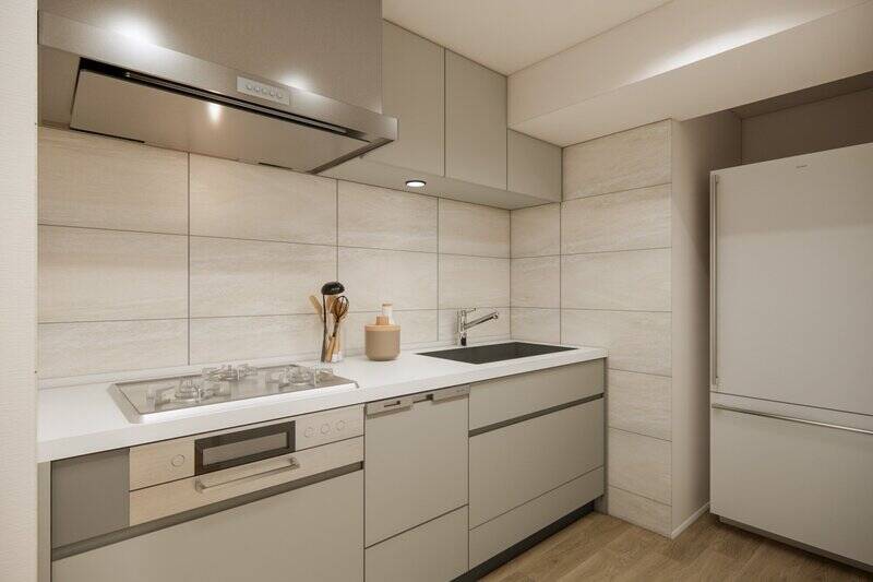 キッチンは3口コンロタイプで食洗機付き。壁は大判タイル貼りで、上品な印象に仕上げます。