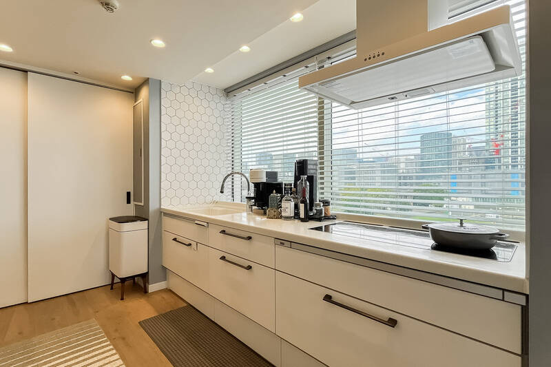 両側の壁にヘキサゴンタイルがあしらわれたキッチン。正面の窓からは、外の景色が視界いっぱいに広がります。