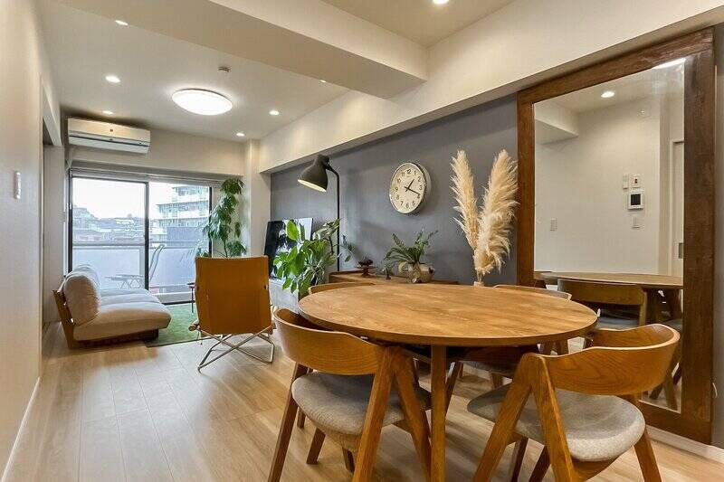 まずは広さ約14.1帖のLDKから。南西向きのバルコニーに面した窓から、自然光がたっぷり入ります。元々は全体的に白の石膏ボードだった壁は、DIYで一部のみニュアンスのあるグレーにペイントすることでアクセントにしたそう。