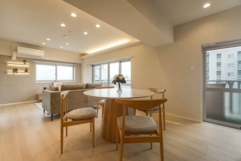 というわけで13階の住戸にやってきました。こちらのLDKは約17.4帖で、東・北の二面採光です。梁が下がっていて天井高が低い部分があるのを、間接照明を使ってうまく空間に広がりを持たせていますね。