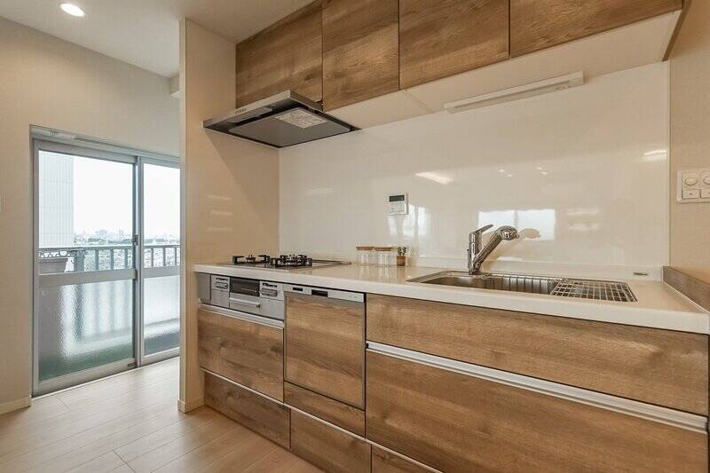 ナチュラルな雰囲気の木目調キッチン。食洗機を完備しており、収納もたっぷり備わっています。