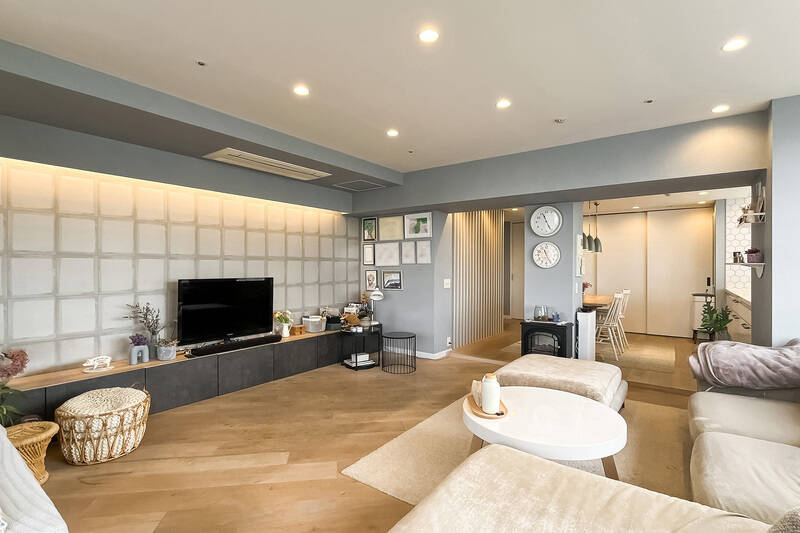 リビングのフローリングは斜め貼り。壁一面に貼られたタイル調のクロスが、空間のアクセントに。