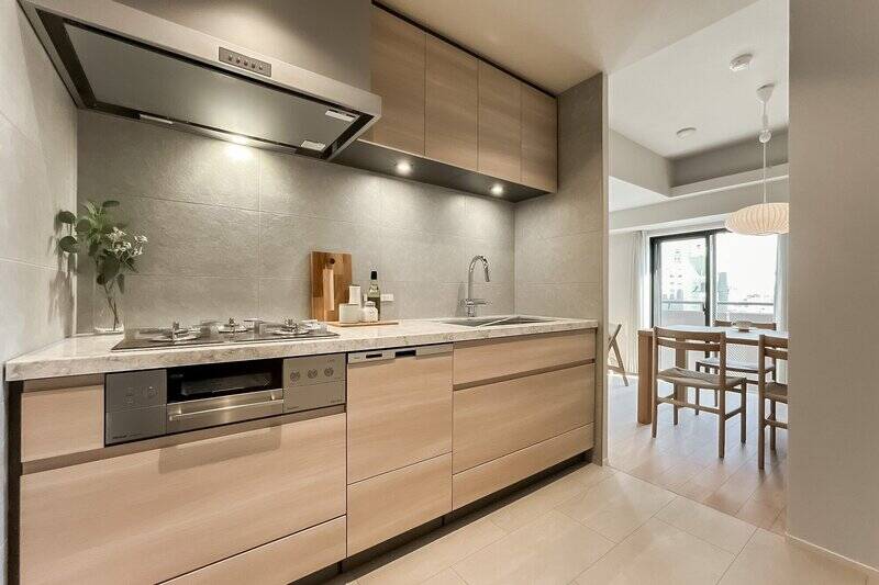 キッチンは3口コンロタイプで食洗機付き。石調のタイルがあしらわれ、ラグジュアリーな印象です。