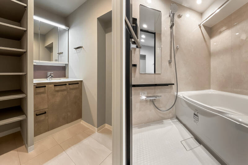 <b>左・</b>洗面台の横には、タオルなどを収納しやすそうな可動棚（6段分）を設置済み。／<b>右・</b>浴室乾燥機・追焚き機能付きのユニットバス。