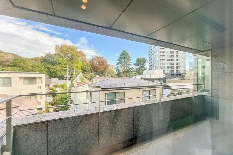 一面の窓の先には専用バルコニーが。前方に広がる緑は「白金二丁目第二緑地」のもの。