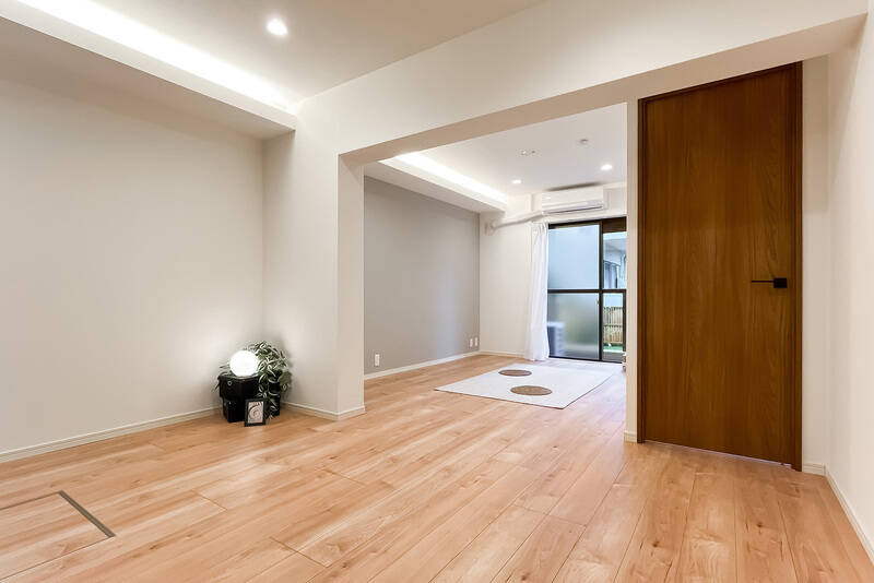 約12.7帖のLDKは、白とウッドテイストのシンプルな内装。右手の扉の先は洋室です。