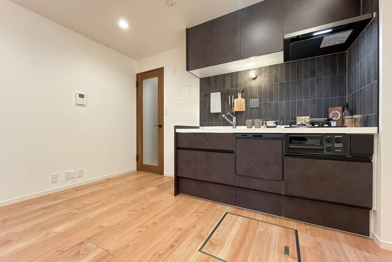 明るいナチュラルテイストの内装に対して、キッチンは落ち着いたブラウンで、空間にキリッとしたアクセントを添えています。キッチンは、2口ガスコンロ・食洗機を完備。