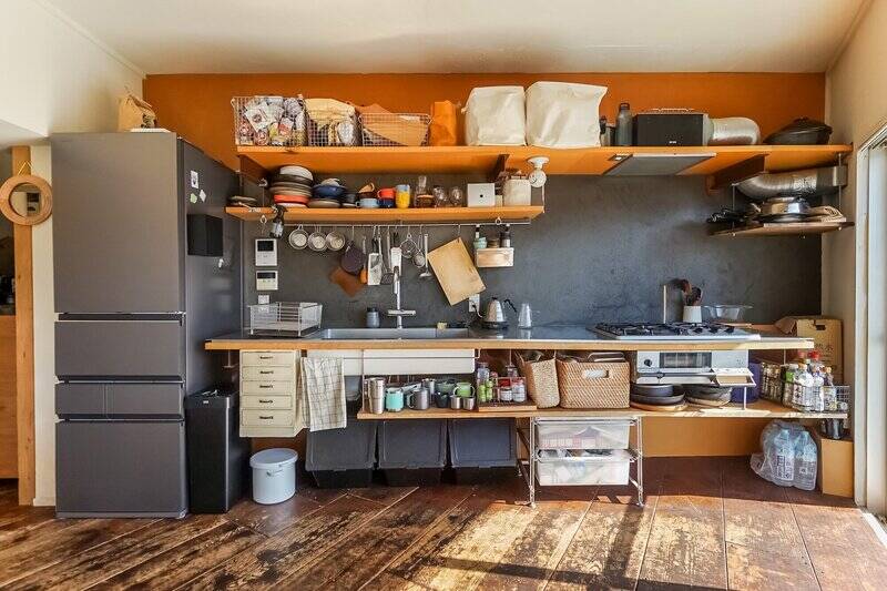 ステンレス製の天板をデザインのベースに、MDF（中密度繊維板）と特注品の鉄柱を組み合わせて造ったキッチン。天板下の引き出しは、古道具屋さんで見つけた書類ケースを設置したのだそう。