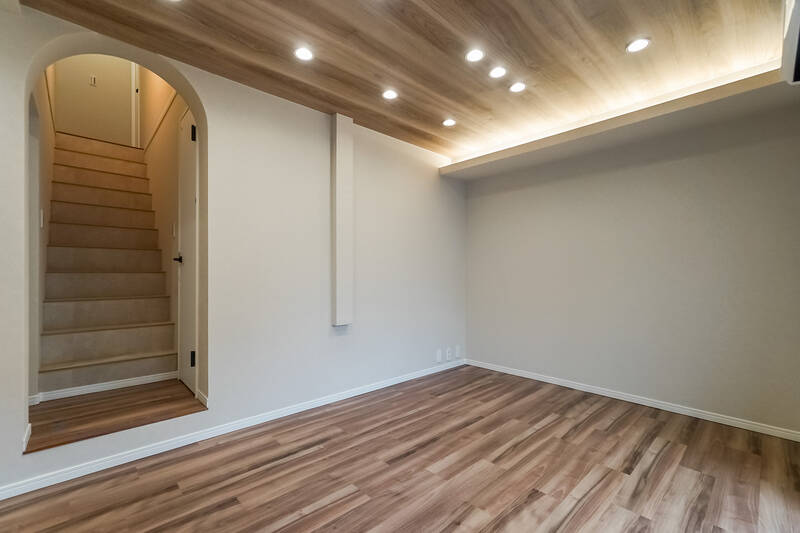 上階につながる階段へは、壁をアーチ型にくり抜いたちょっぴり特別感ある空間を通ってアクセスします。天井の間接照明も相まって、ほどよく凝った印象を受ける内装です。