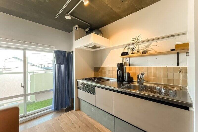 キッチンは、広さを最大限に活かした壁付けタイプ。一枚ずつ表情の異なるタイルやオープン棚で、既製品のみでは叶えられない素敵な仕上がりになっています。