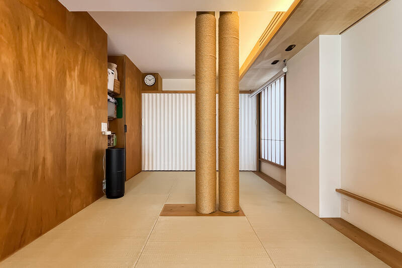 左手には引き戸で目隠しできる収納スペースが。中心にある麻紐が巻かれたふたつの円柱は、上下階を結ぶパイプです。