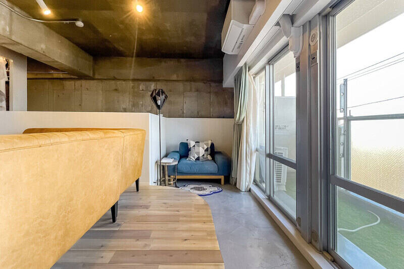 窓際はまわりから一段下げて土間仕上げにすることで、インナーバルコニーのようなスペースに。床をアールに切り取っている工夫も可愛い!