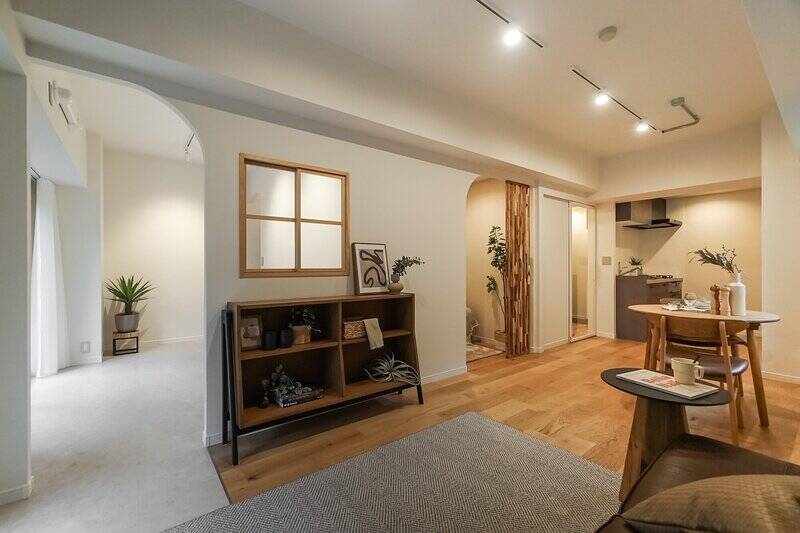 ふたつの洋室に敢えてドアを付けず、壁の高い位置からアールを描いて切り取ることで、開放的でアートのような空間に仕上げられていますね。さらにLDK窓辺〜洋室Bにかけての床材はモルタル風のフロアタイルで、内と外をつなぐインナーテラスのような印象に。