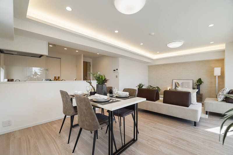 リビング奥の壁面にはベージュのアクセントクロスがあしらわれています。折り上げ天井部分に間接照明が入っているおかげで、空間に奥行きが生まれているのもGOODです。