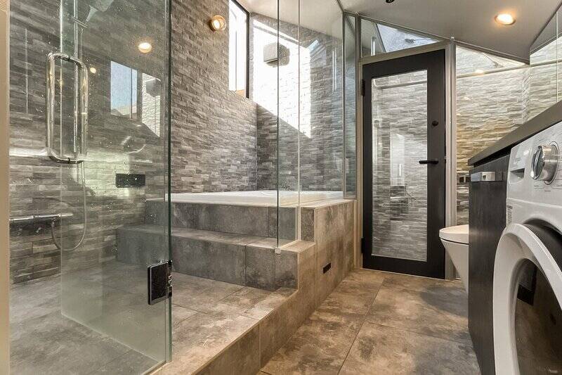 洋室の奥の明るさに誘われるようにガラスドアを開けた先には、浴室・洗面台・トイレがまとまっています。