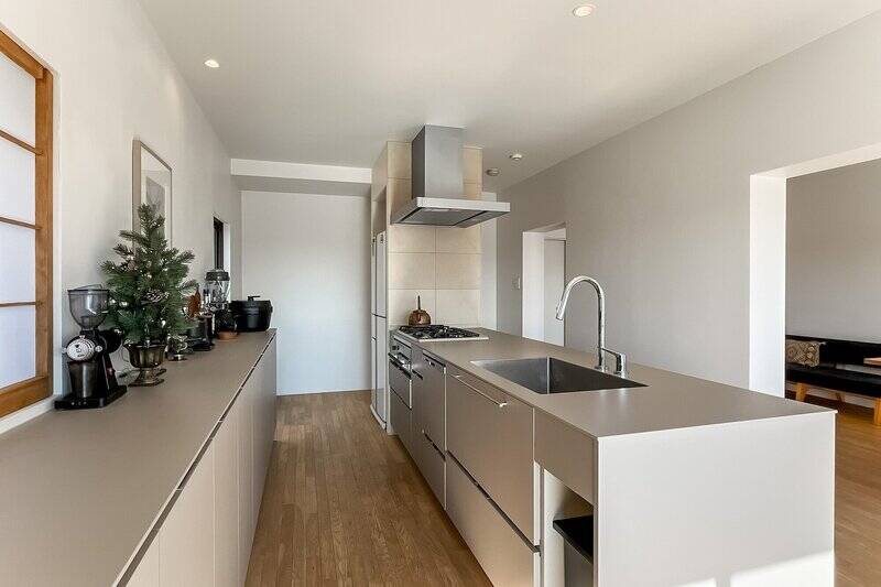 キッチンは食洗機とグリルをビルトイン。本体も背面収納もベージュで揃えたデザインがスタイリッシュです。天板が大きいので、調理も捗りそうですね。