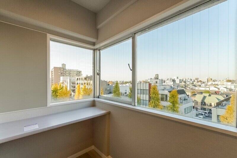 北〜西向きにあるコーナーサッシからは、青梅街道沿いのイチョウ並木がチラリ。デスクは備え付けです。