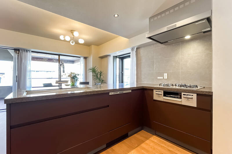 キッチンは3口コンロタイプで食洗機付き。天板にはフィオレストーンを使用し、高級感あるデザインに仕上げています。