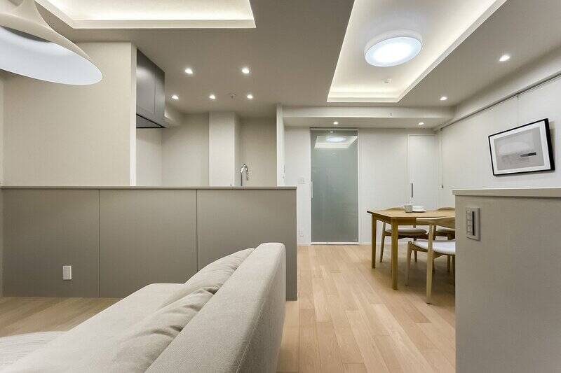 窓を背にしたカット。ライトグレージュを基調とした内装で、間接照明を仕込んだ折り上げ天井がアクセントに。