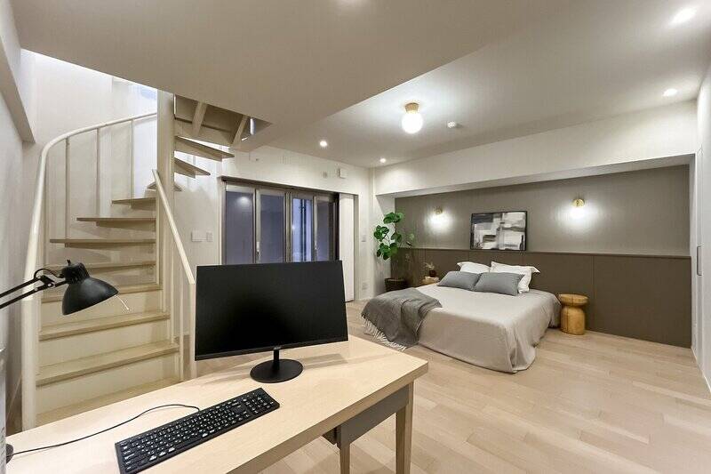 下階にある洋室は、まるでもうひとつのリビングスペースのよう。ホテルのようなブラケットライトとヘッドボードをあしらい、ラグジュアリーな印象に仕上げました。ステージングでは、クイーンサイズのベッドを配置。セミダブルベッド2台もゆとりをもって置けますよ。