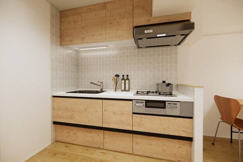 キッチンは3口コンロタイプ。壁は正方形のタイル貼りで、空間のアクセントになっています。