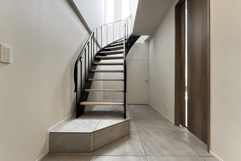 玄関扉を開けると、正面には屋上へと続く階段が(手すりにはさり気なく三日月のようなモチーフが)。右手にある引き戸の先にLDKが位置します。