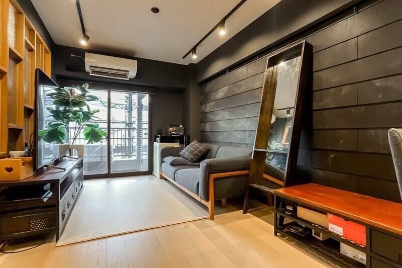 居住空間に入ると、ぐっとディープな印象に。外装材のような壁面が印象的で、ピクチャーレールも備わっています。