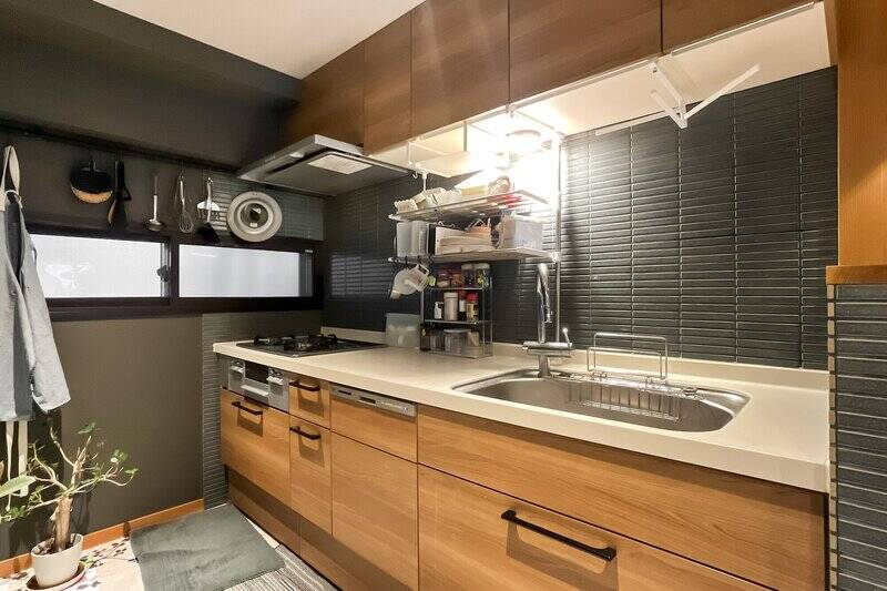 ブラックのタイルがあしらわれたキッチン。共用廊下に面した小窓が付いています。