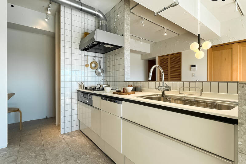 食洗機、浄水器一体型水栓、3口ガスコンロにグリル付き。コンロまわりはタイル貼りになっています。