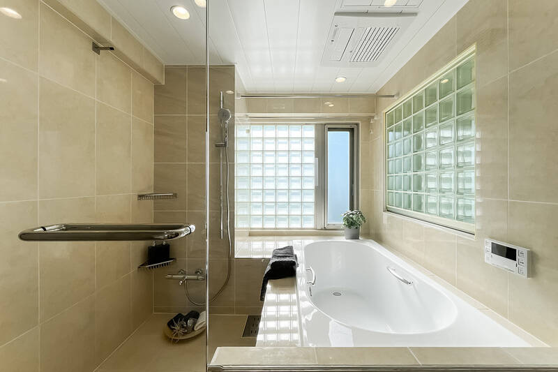 ガラスブロックが印象的な、在来工法の浴室。浴室乾燥機・追焚き機能付きです。