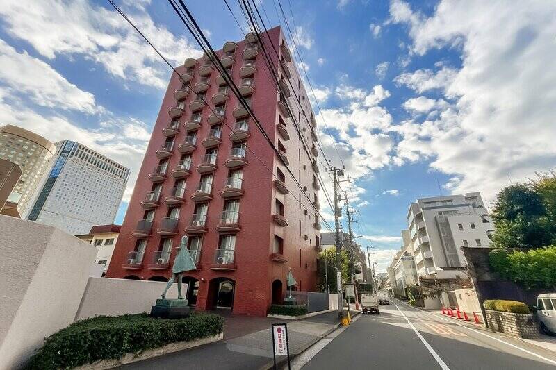 レンガタイルに、曲線を描くバルコニーがアクセントになった外観。1974年竣工、総戸数15戸のマンションです。