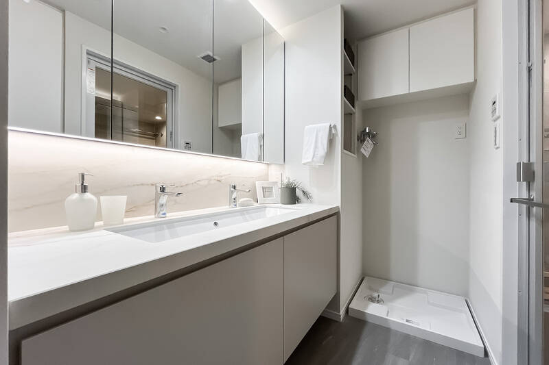 キッチンと同じ田中工藝社製の洗面化粧台は、横長のシンクに水栓がふたつ。おふたり並んで身支度していただけます。洗面化粧台の横と背面に、リネン類や日用品をしまえる収納を確保。